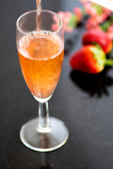 A glass of rose wine with strawberries
