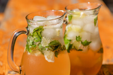 two mugs with mojito on wooden table