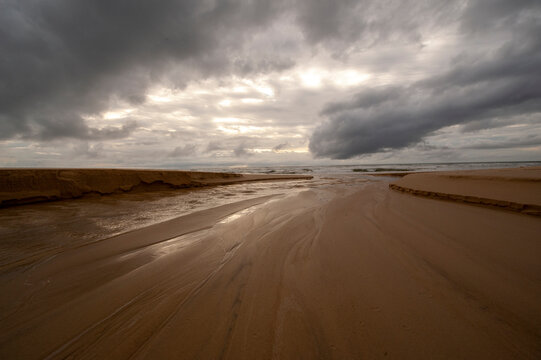 30/5000 dark clouds over the sandy beach © Pavel