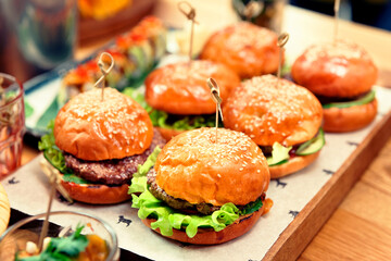 Hamburgers on wooden board, toned