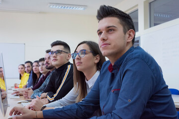 College students sitting in a classroom, using laptop computers during class listening lesson about covid19  virus