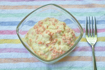 coleslaw chop cabbage with carrot in mayonnaise sauce in glass bowl with silver fork