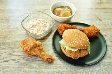 hamburger and fried chicken with coleslaw eat couple mashed potato gravy sauce on table