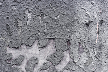 Gray cracked stucco on the wall. Building's facade. Multilayer painting