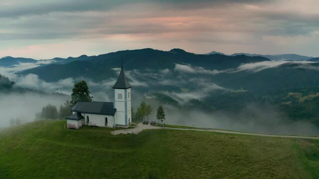 Jamnik, Slovenia - 4K aerial drone footage of flying slowly towards St.Primoz church on a foggy summer morning