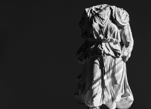 Black and white photo of ancient roman headless statue wearing a tunic