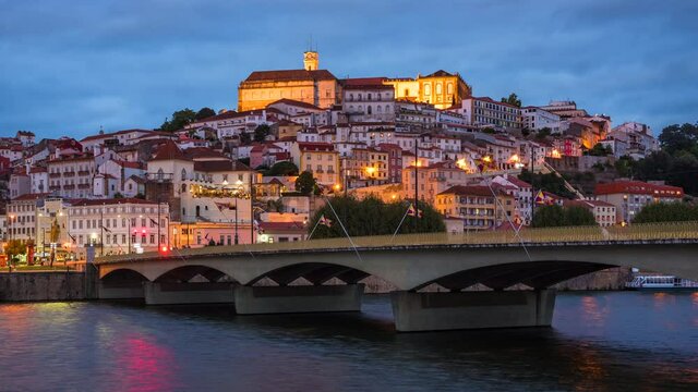 Coimbra, Portugal, zoom out timelapse view of the former Portuguese capital including historical landmark University of Coimbra and Mondego River at dusk.