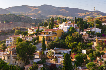 Fototapeta na wymiar Houses of Rincon de la Victoria in Malaga city, spain. White houses with trees in the mountain. 