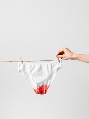 Woman hangs underwear on clothesline, concept content for feminist blog, poster about women's...