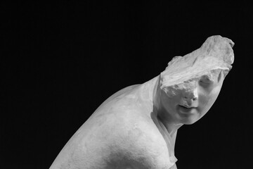 Black and white photo showing ancient roman statue with a broken head
