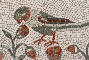 Colorful ancient mosaic showing a little bird among flowers