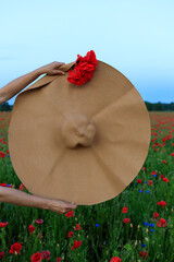 hat in a field of poppies