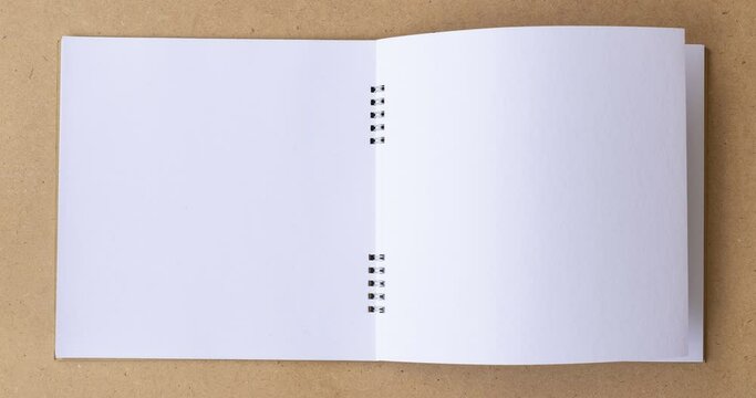 4k Stop motion book animation open white blank page for writing on wooden background.
