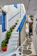 Picturesque scenic narrow Greek streets with traditional whitewashed houses with blue doors windows of Mykonos town in famous tourist attraction Mykonos island, Greece