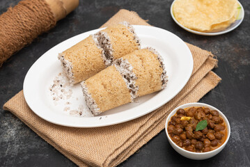 Popular South Indian breakfast puttu / pittu made of Wheat flour and coconut in a bamboo mould, with banana, Kerala, India. Bamboo puttu prepared in the bamboo utensil. 