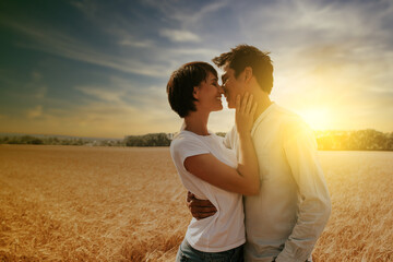 portrait of a couple kissing in a wheat field under a sunset