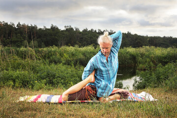 Handsome fit man doing yoga at the park