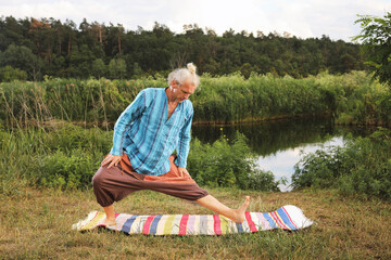 Handsome fit man doing yoga at the park