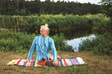 Handsome fit man doing yoga at the park
