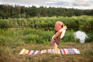 Handsome fit man doing yoga at the park