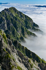 夏の快晴の北アルプス槍ヶ岳山頂から見た北鎌尾根と雲海。