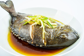 A dish of home-cooked steamed brown blue roe on a white background