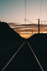 View of the railway tracks and the dark sunset