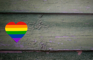 Rainbow heart on green wooden background