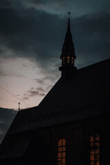 Church against the background of a bright sky among dark clouds