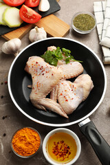 Composition with raw chicken and spices on gray background. Cooking chicken
