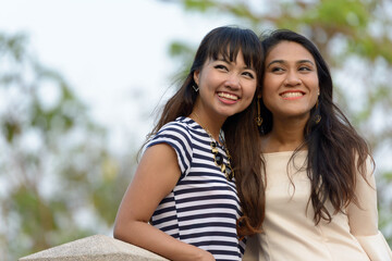 Portrait of two happy young Asian women together at the park