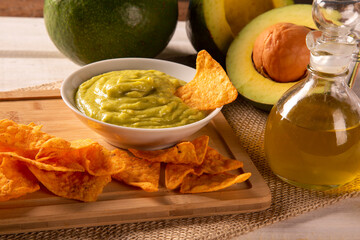 Guacamole avocado, lime, tomato, onion and cilantro, served with nachos - Traditional Mexican snack.
