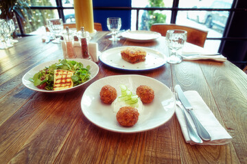 Set of three Greek dishes - fried Saganaki cheese, moussaka and zucchini fritters, toned