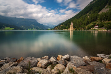 Curon bell tower submerged in the water, Resia Lake, Italy