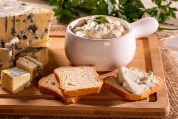 Blue cheese cream and toasted bread on wood background. Pate de gorgonzola in Brazil.
