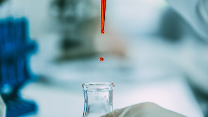 close up. background image of a drop of red liquid in a laboratory pipette.