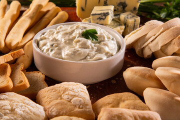 Blue cheese cream and toasted bread on wood background. Pate de gorgonzola in Brazil.