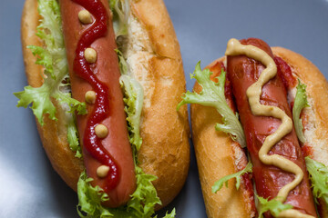 Two homemade classic hot dogs with yellow mustard, ketchup and fresh green salad.American Fast Food. National holiday hot dog Day.Close up.