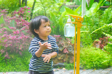 Little child boy using Alcohol gel bottle washing and cleaning hand for prevent Corona virus or Covid-19 disease