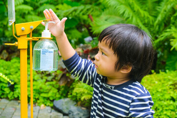 Little child boy using Alcohol gel bottle washing and cleaning hand for prevent Corona virus or Covid-19 disease