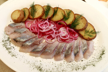 Sliced herring with potatoes and marinated onions