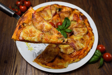 
pizza with meat and tomatoes under cheese