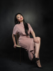 Asian woman model in long dress sitting