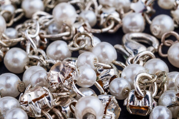 backdrop of pearls, silver chains and rhinestones close up