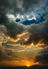 Cumulus clouds on background of colorful sunset