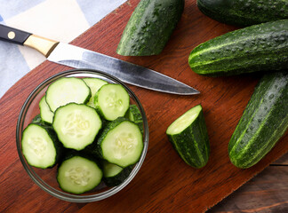 Whole and sliced cucumbers in a plate. The view from top