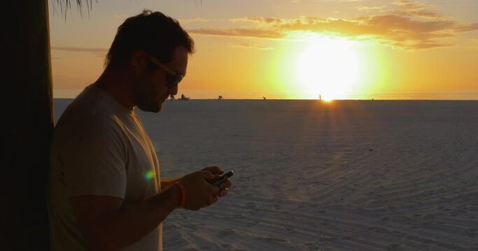 486 Closeup of a Person on his phone while looking into the sunset in Florida