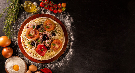 Various vegetables at wooden rustic background with copyspace on round pizza desk. Set of fresh vegetables. Egg, tomatoes, pepper, lettuce, onion, garlic, onion. Pizza ingredients.