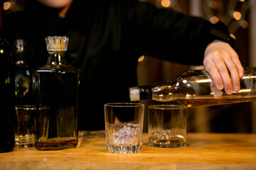 Barman pouring whiskey glass beautiful night