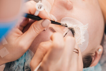 The process of gluing artificial eyelashes - a make-up master at work
